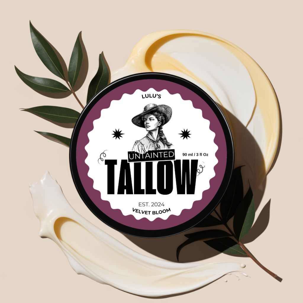 "Velvet Bloom Whipped Tallow Cream by Lulu's Untainted Tallow, 90ml tin with a vintage-inspired label. The label features a portrait of a woman in classic attire with the product name 'UNTAINTED TALLOW' in bold. The tin sits on a creamy swirled background with green leaves, giving a natural, earthy feel."